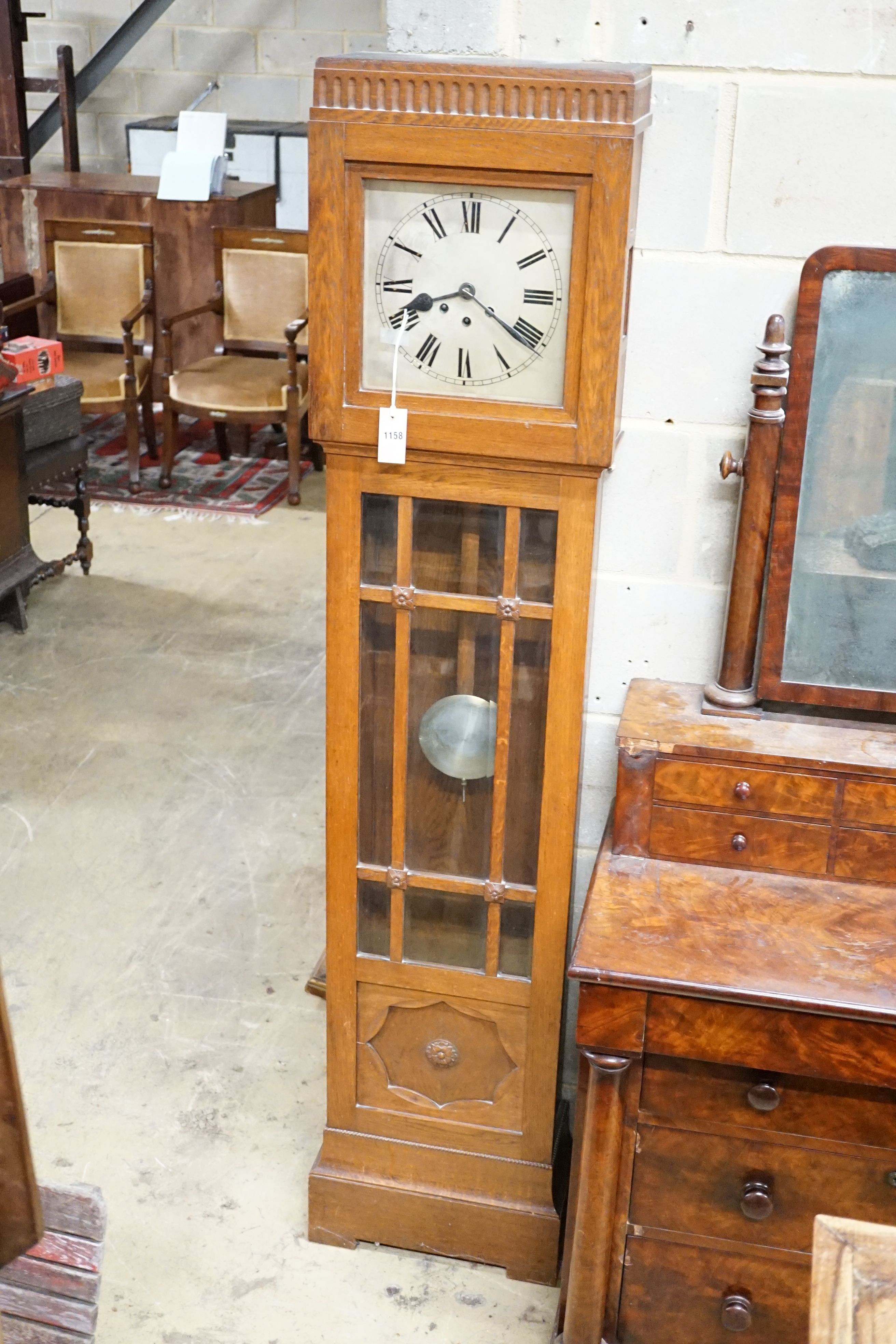 A 1930's chiming longcase clock, square silvered Roman dial in carved and panelled oak case, height 183cm